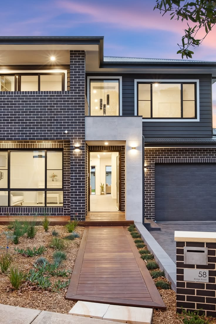 Modern Australian home with dark brick facade and warm architectural lighting